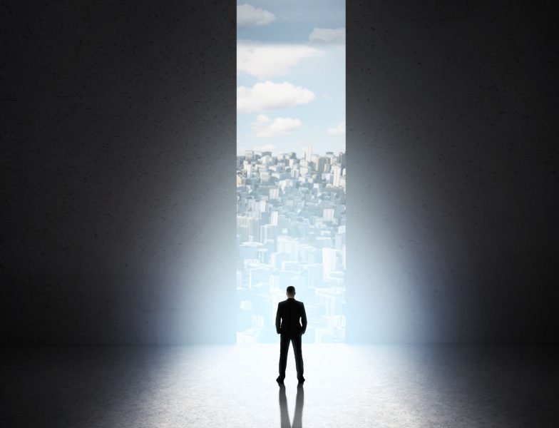 Start of new life. Man silhouette in front of big concrete doors with city view, panorama, copy space